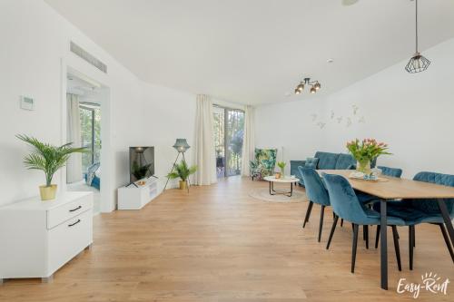 a dining room and living room with a table and chairs at Apartamenty Pinea z widokiem na morze Easy - Rent Apartments in Pobierowo
