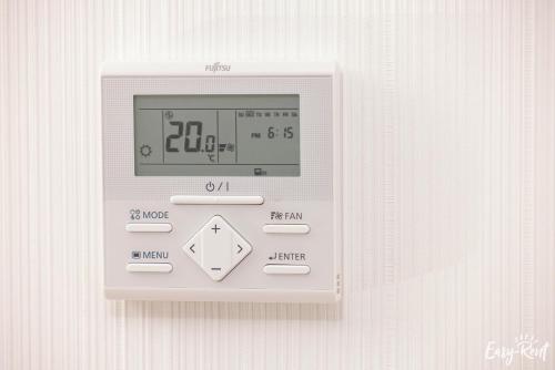 an electronic clock on a wall with a clock on it at Apartamenty Pinea z widokiem na morze Easy - Rent Apartments in Pobierowo