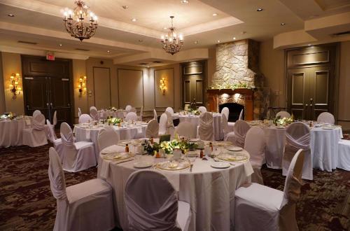 a banquet room with white tables and chairs and a fireplace at Best Western Plus Stoneridge Inn & Conference Centre London Ontario in London