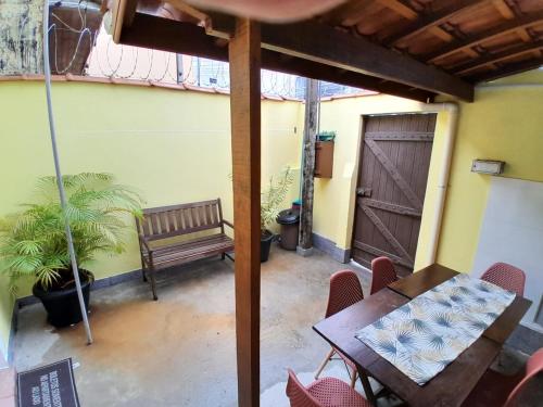 a patio with a bench and a table and chairs at Recanto São Sebastião in São Sebastião