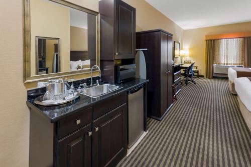 a hotel room with a sink and a bedroom at Best Western Sunrise Inn & Suites in Stony Plain