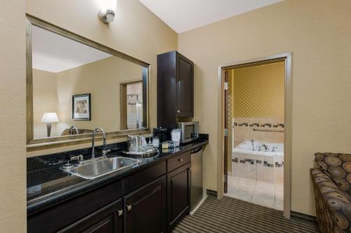 a bathroom with a sink and a bath tub at Best Western Sunrise Inn & Suites in Stony Plain