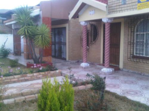 a house with two palm trees in front of it at Guest House Macauly in Johannesburg