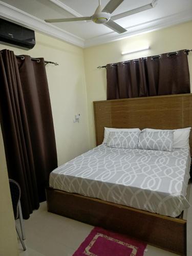 a bedroom with a bed with a wooden headboard at Résidence lynda prestige Ouaga 2000 in Ouagadougou