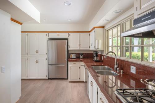 a kitchen with white cabinets and a stainless steel refrigerator at La Jolla Shores Family Getaway in San Diego