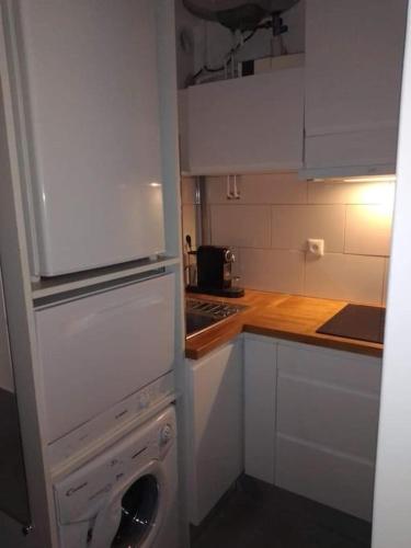 Il comprend une cuisine équipée d'un lave-linge et d'un réfrigérateur blanc. dans l'établissement Appartement tout équipé village naturiste à 100 m, au Cap d'Agde