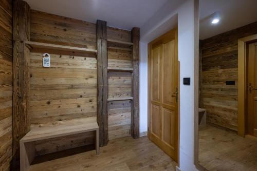 Zimmer mit Holzwänden und Holztür in der Unterkunft Hotel Olympie in Špindlerův Mlýn