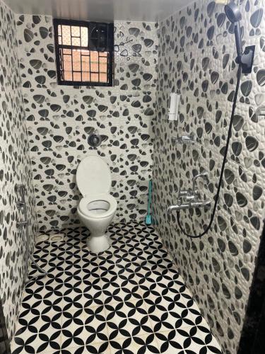 a bathroom with a toilet and a shower at Gonsalves villa in Arossim-Cansaulim