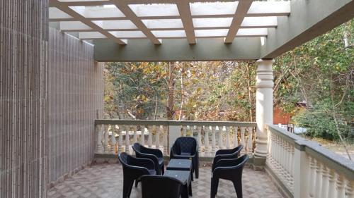 a row of chairs and tables on a porch at Gonsalves villa in Arossim-Cansaulim