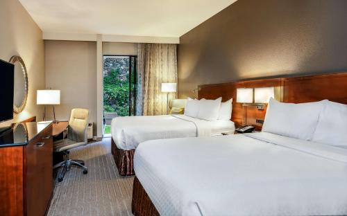a hotel room with two beds and a television at Sonesta Charlotte Lower South End in Charlotte