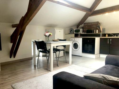a kitchen and living room with a table and chairs at L'éden Quercynois in Souillac