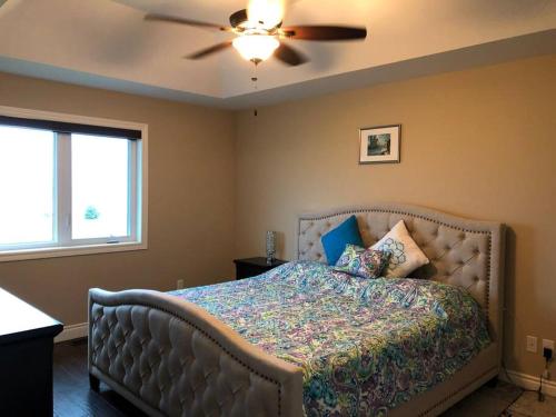 a bedroom with a bed with a ceiling fan at Merlin Home With Amazing Lake Erie Views in Tilbury