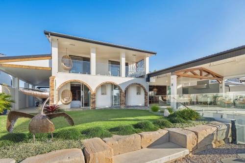 an exterior view of a house with a yard at Waterfront Bliss on Maroochydore Canal in Maroochydore