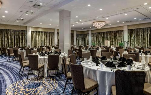 a banquet room with tables and chairs and a chandelier at Sonesta Charlotte Lower South End in Charlotte