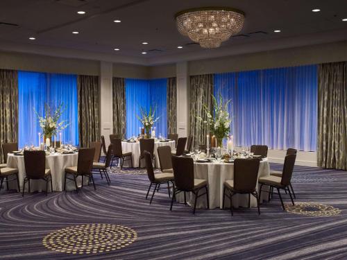 a conference room with tables and chairs and a chandelier at Sonesta Charlotte Lower South End in Charlotte