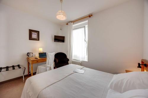 a person laying on a bed in a room with a window at Brit Hotel Confort Bagnoles Normandie in Bagnoles de l'Orne