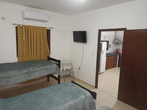 a room with two beds and a kitchen with a refrigerator at Mi Luna Tucumana in Fernández
