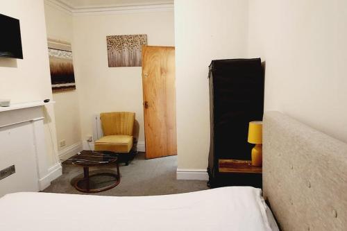 KentにあるOne Bed Comfort Studio Apartmentのベッドルーム1室(ベッド1台、椅子1脚、ドア付)