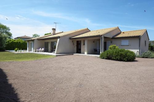 a house with a gravel driveway in front of it at Évasion à proximité de Bordeaux - Piscine Privée in Podensac