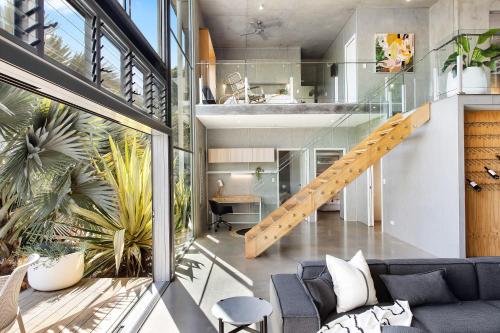 a living room with a staircase in a house at The Opal at Coolum - Mountain and Ocean Views in Yaroomba