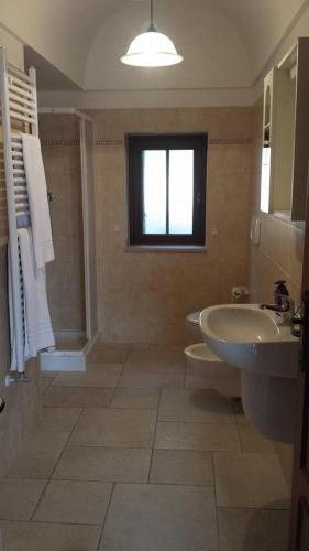 a bathroom with a sink and a toilet and a tub and a sink at Residenza Di Nonna Giulia in Locorotondo