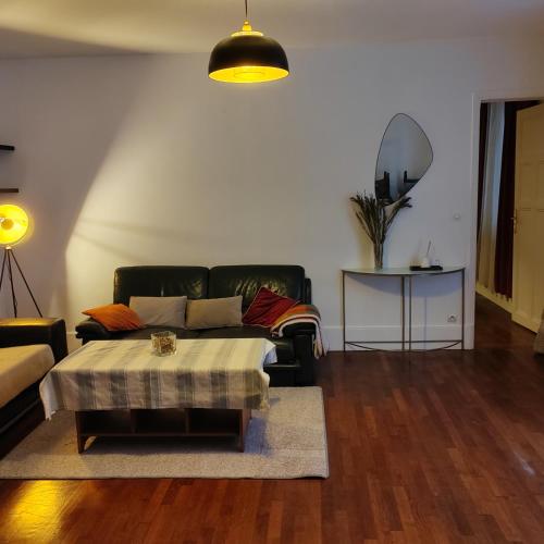 un salon avec un canapé et une table dans l'établissement Le bonheur Pantinois, à Pantin