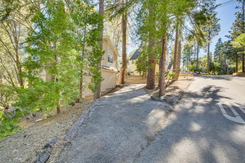 an empty road in front of a house with trees at Chic Lake Arrowhead Retreat 4 Seasons of Fun! in Lake Arrowhead