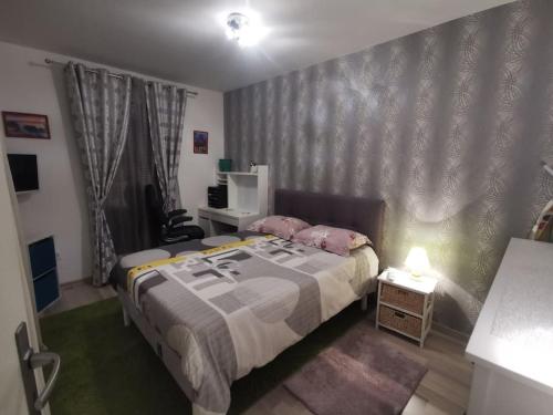 une chambre avec un lit avec des oreillers roses dessus dans l'établissement Appart 42 m2 à 1 min de l'A13 conforme photos, place de parking gratuite, wifi, à Magnanville