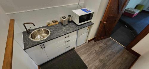 a small kitchen with a sink and a microwave at Magnolia Park in Tamahere