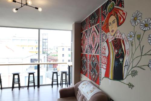 a large painting of a woman on a wall in a room at Hostel 90pods & C O working in Shkodër