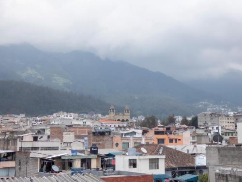 a city with buildings and a mountain in the background at Hotel El Ejido in Quito
