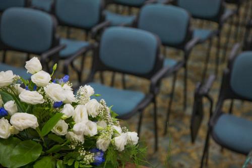 a vase filled with white flowers in front of chairs at San Gabriele in Loreto