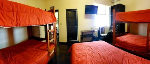 a room with three bunk beds in a room at Llaqta Wasi in Lima