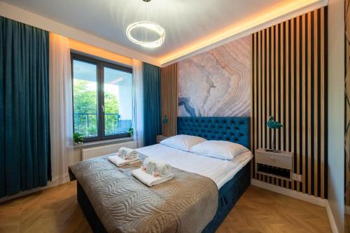 a bedroom with a bed with two towels on it at Golden Park Aparthotel in Szczecin