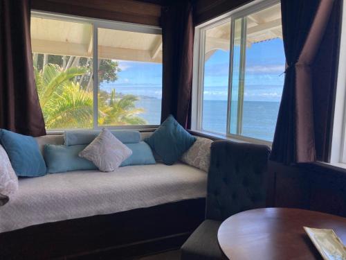 un divano seduto di fronte a una grande finestra di Hilo Bay Oceanfront Bed and Breakfast a Hilo