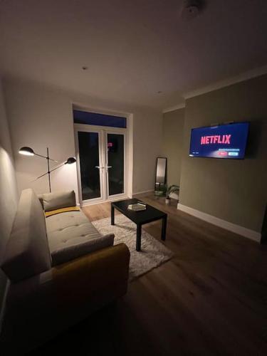 un salon avec un canapé et une télévision au mur dans l'établissement Whole House Modern Two Bedroom in Newcastle - Free Parking, à Newcastle upon Tyne