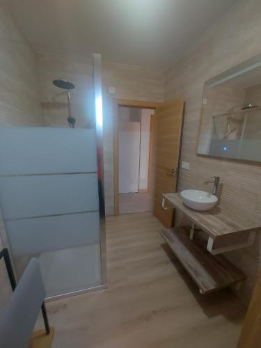 ein Badezimmer mit Waschbecken und Spiegel in der Unterkunft Piso Escaravello - Laxe in Laxe