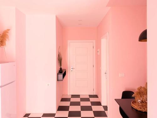 a hallway with pink walls and a checkered floor at PROMO Elegant Apartments NEW - Colorful by the sea in Durrës