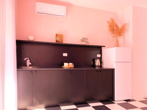a kitchen with a black counter and a white refrigerator at PROMO Elegant Apartments NEW - Colorful by the sea in Durrës