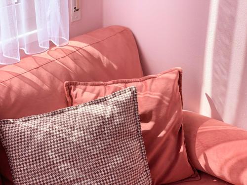 a brown couch with a checkered pillow on it at PROMO Elegant Apartments NEW - Colorful by the sea in Durrës