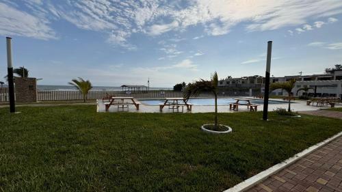 a group of picnic tables in a park near the water at Ecusuites Jacuzzi en Playas Vista Mar in Playas