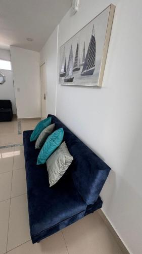 a blue couch with pillows on it in a room at Ecusuites Jacuzzi en Playas Vista Mar in Playas
