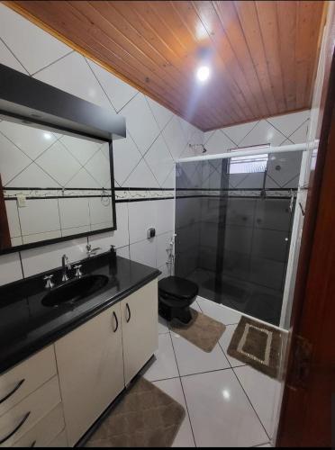 a bathroom with a shower and a sink and a toilet at Casa da Dôdi in São Joaquim