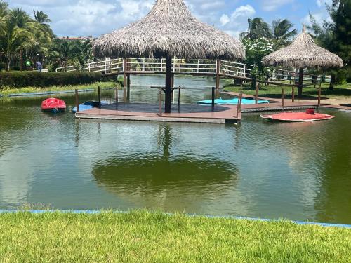 une piscine d'eau avec des parasols et des planches de surf dans l'établissement Apartamento em Aquaville Resort, à Aquiraz