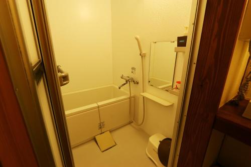 a bathroom with a shower and a tub and a toilet at 旗籠白忠 in Nagahama