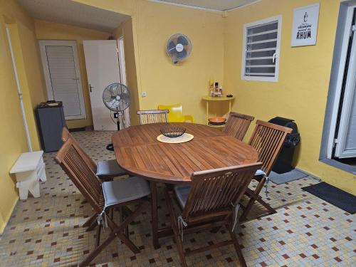 a dining room with a wooden table and chairs at Fait bon vivre ! in Sainte-Anne
