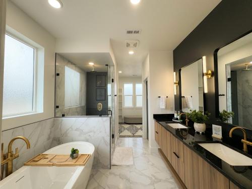 a large bathroom with two sinks and a tub at Sport Court! Hot Tub! Putting Green! Bunk Room! in Lava Hot Springs