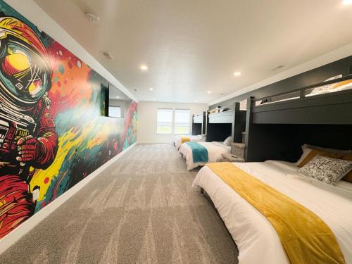 a bedroom with two beds and a painting on the wall at Sport Court! Hot Tub! Putting Green! Bunk Room! in Lava Hot Springs