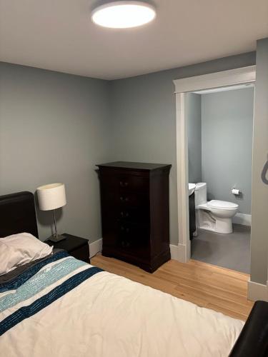 a bedroom with a bed and a bathroom with a toilet at QE Park Garden suite 3BR 1.5Ba in Vancouver