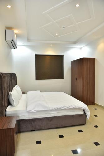 a bedroom with a bed and a projection screen at شقق المكان الراقي للشقق المخدمة in Riyadh